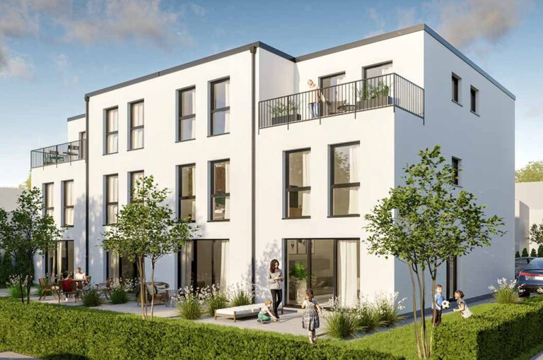 Mehrfamilienhaus mit weißer Fassade, Balkonen und angelegtem Garten.